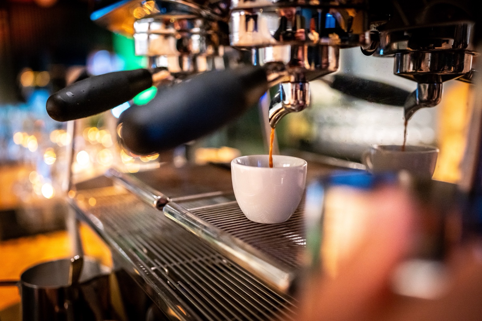 Espresso läuft aus einer Siebträgermaschine in weiße Tassen