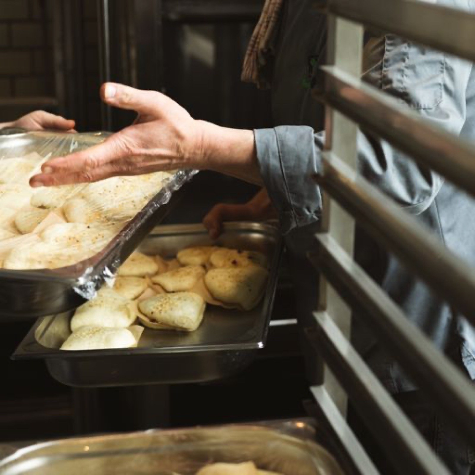 Hände richten die Buffetausgabe mit warmen Speisen her