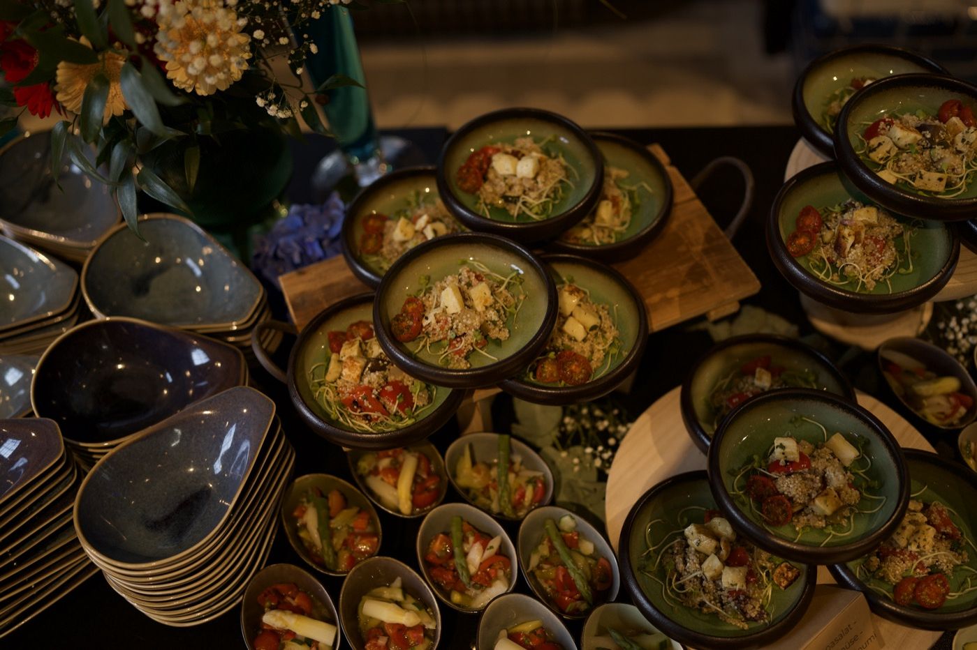 Buffet mit vielen Schalen voller Salate und Beilagen, dazwischen Blumen