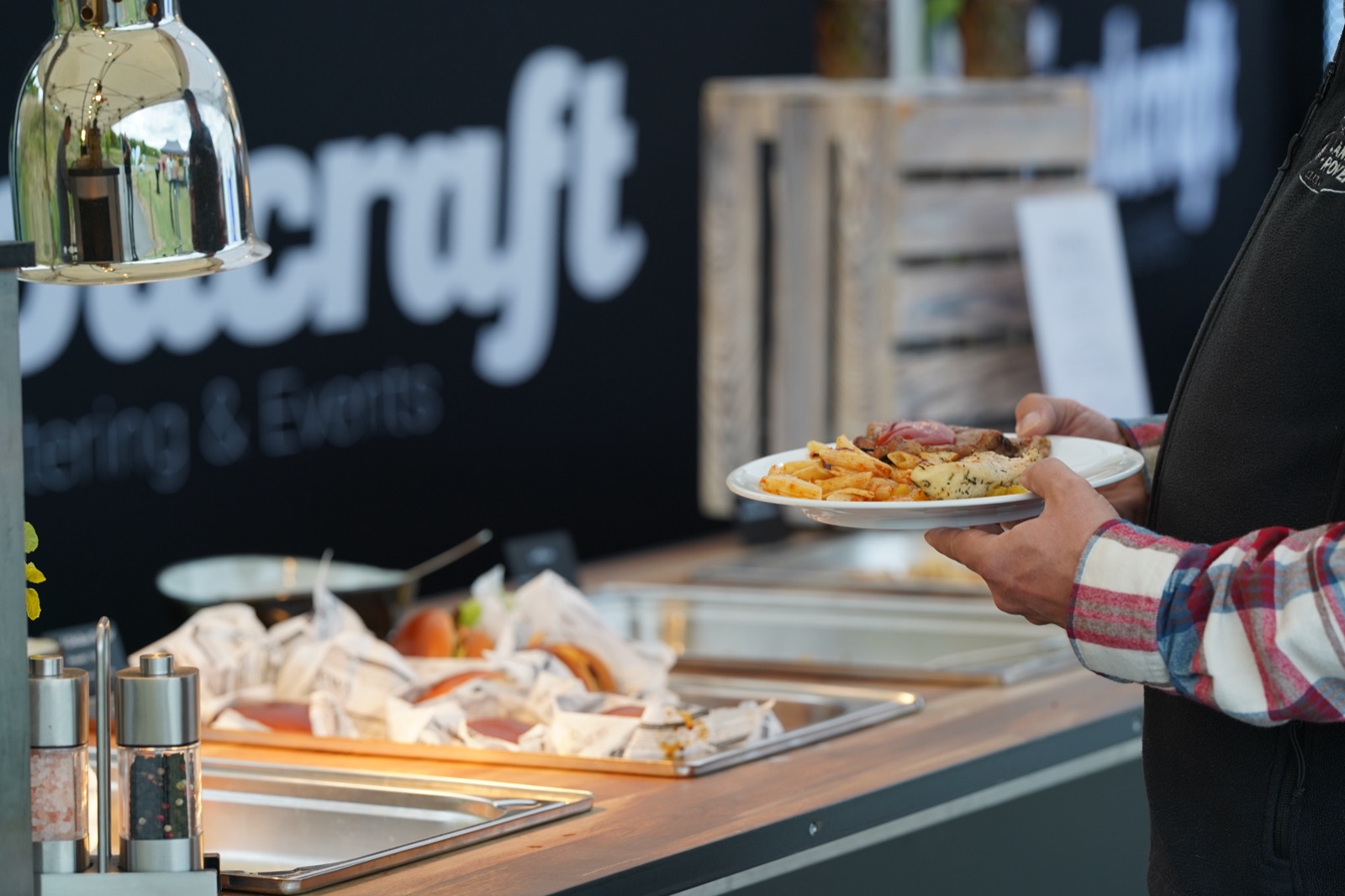 Ein Teller mit Speisen an der Ausgabe vor einem Foodcraft-Banner