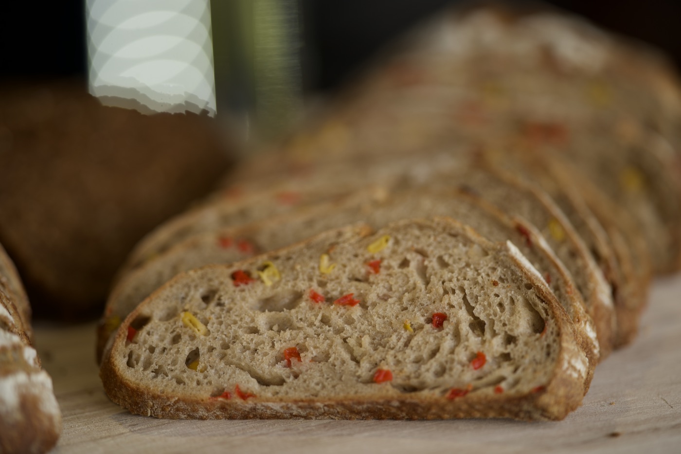 Angeschnittenes Brot mit roten und gelben Stückchen auf einem Brett
