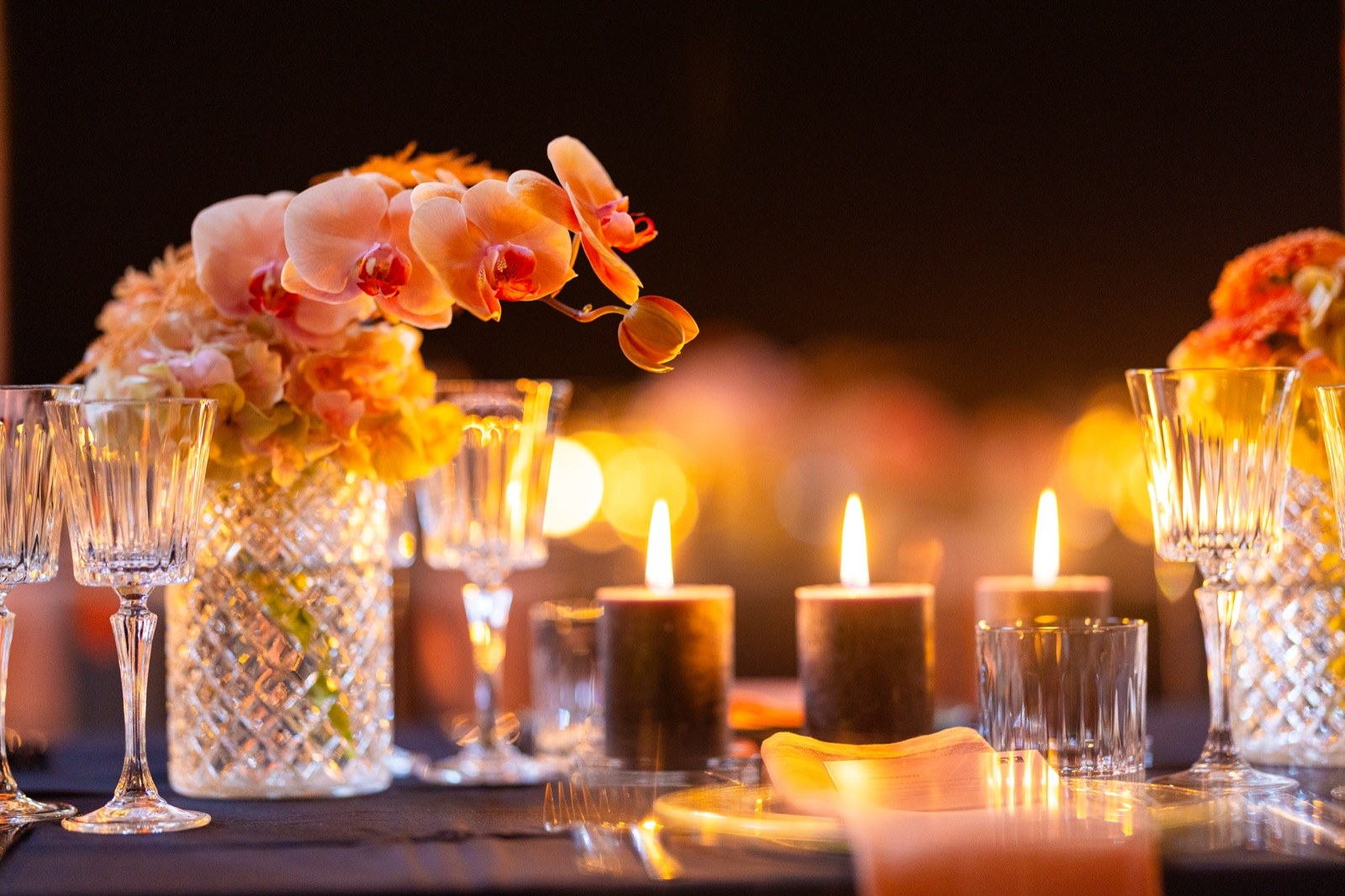 Kerzenlicht und Kristallgläser auf festlich gedeckter Tafel