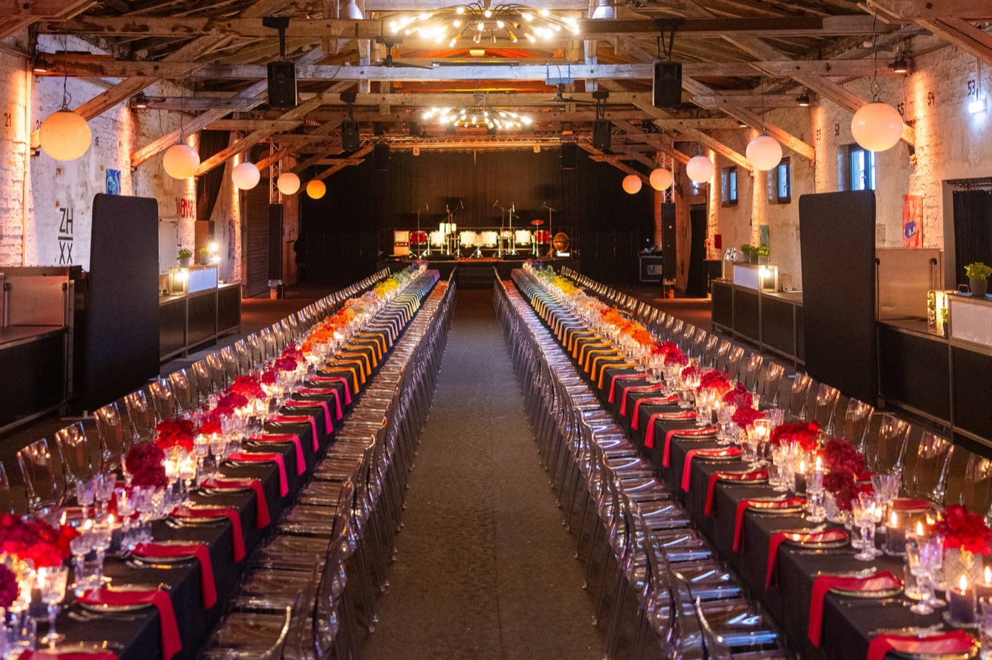 Lange Galatafeln mit roten Läufern, Blumen und warmem Licht in der Halle 6 im Zughafen Erfurt